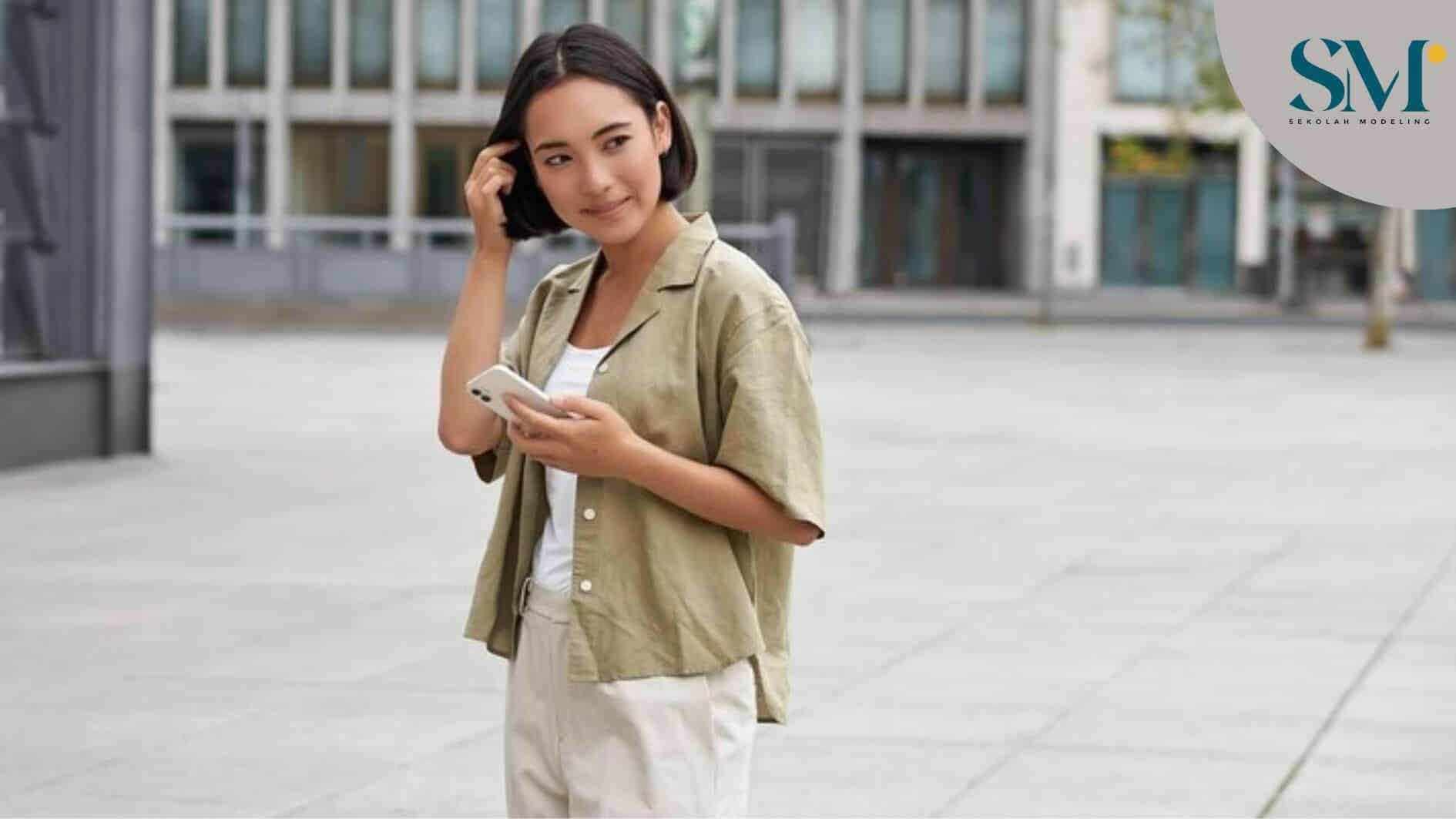 Portrait of asian woman walking in city street style shot of girl with smartphone posing outdoors on