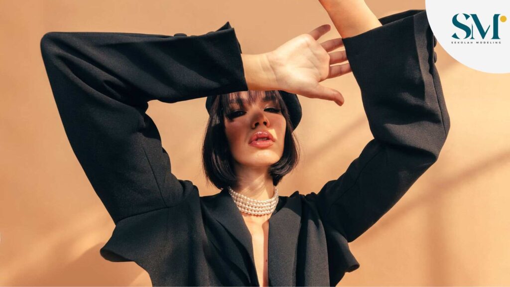 Woman posing wearing black clothes and pearls necklace