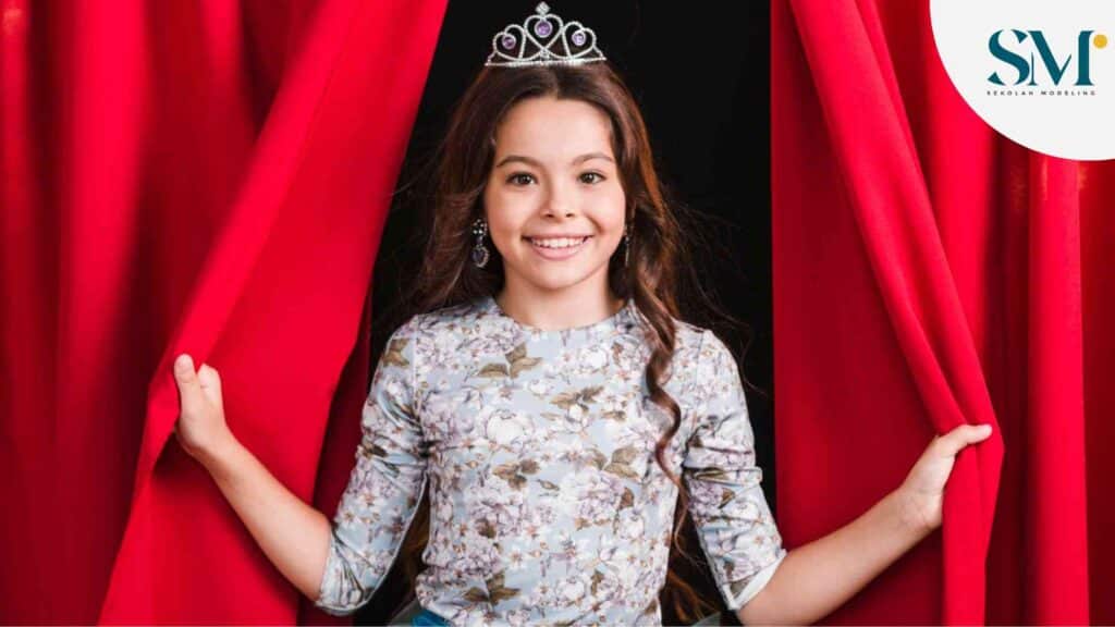 Portrait of smiling girl looking out from red curtain